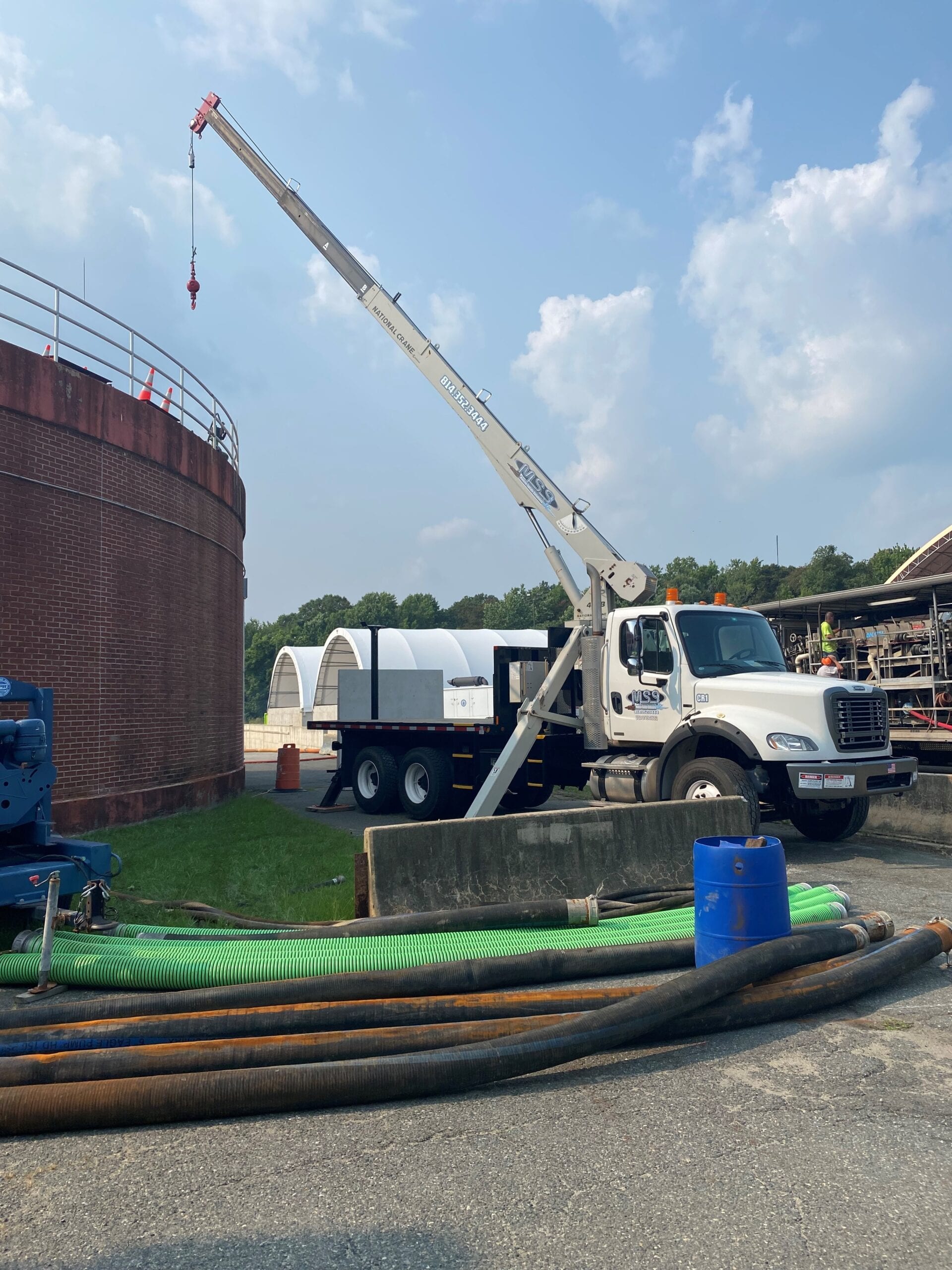 The crane truck setting a sealed container on an active job site